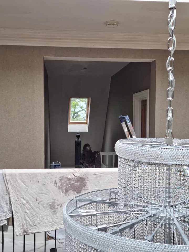 Hallway redecoration with a chandelier and protective dust sheets in place