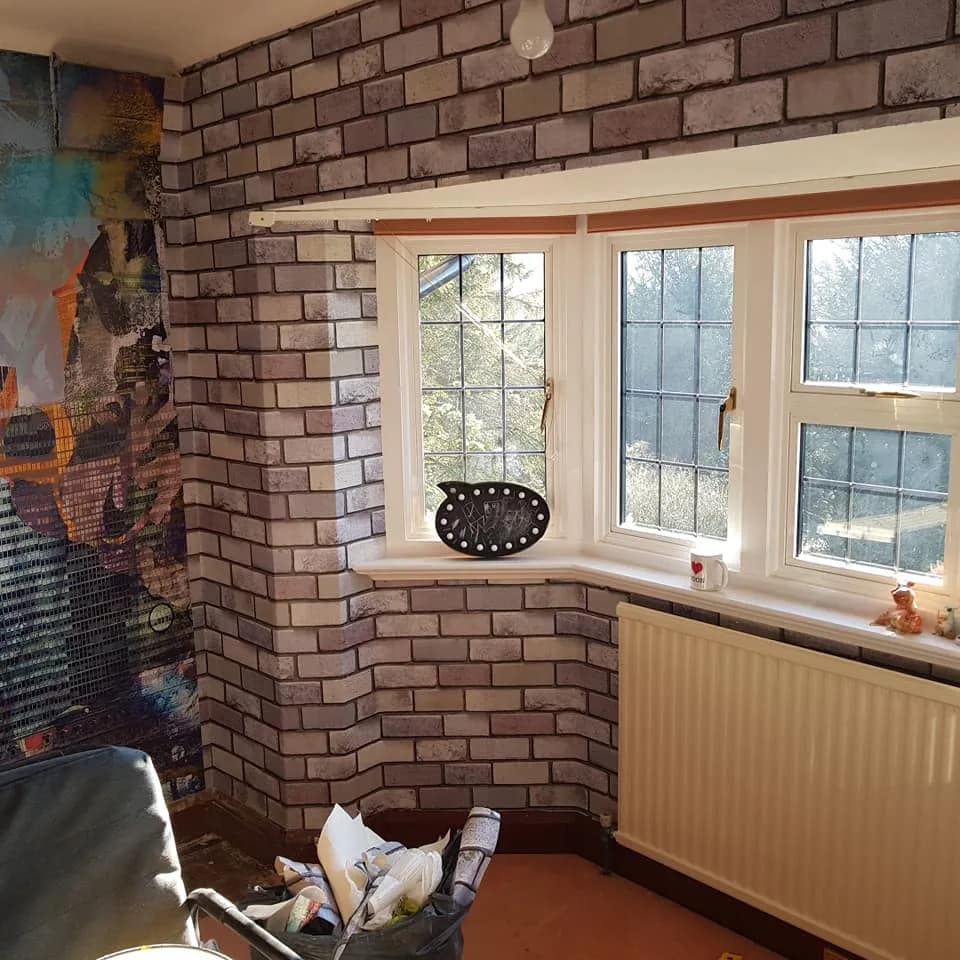 Exposed brick feature wall and painted window reveals in a living room