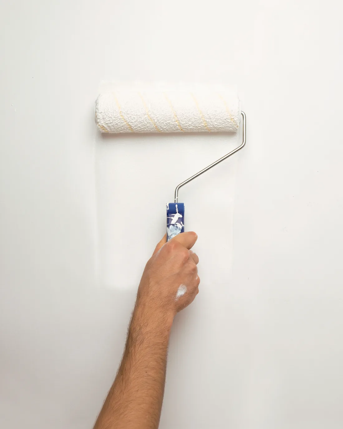 Roller applying a clean white finish to a smooth wall