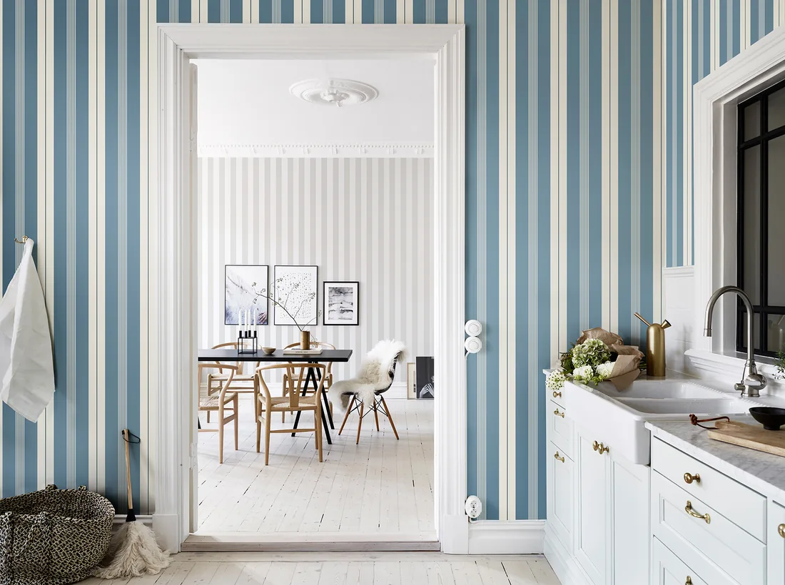 Blue and white striped wallpaper running through a kitchen and dining room