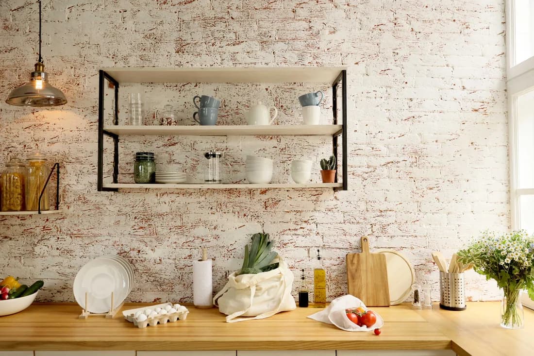 Textured plaster-effect wallpaper behind open kitchen shelving